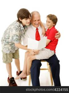 Two adorable boys reading a greeting card to their father. Isolated on white.
