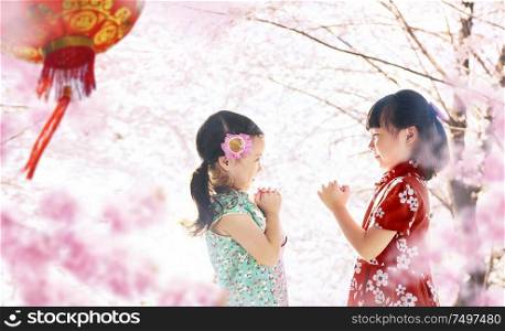 Two adorable girl wearing cheongsam during chinese new year season .