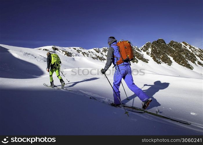 Two alpinist skiers during a ski mountaineering trip.