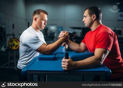 Two arm wrestlers on starting position, wrestling competition. Wrestle challenge, power sport. Two arm wrestlers on starting position, wrestling
