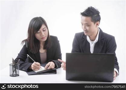 Two asian business in office, business talking with notebook