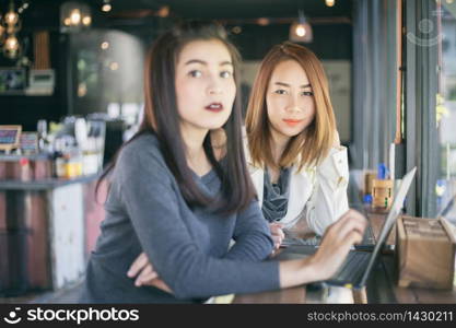 Two Asian business women using notebook working and Discussion of the important contract at office ,soft focus