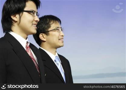 Two asian businessmen posing outdoor at the beach