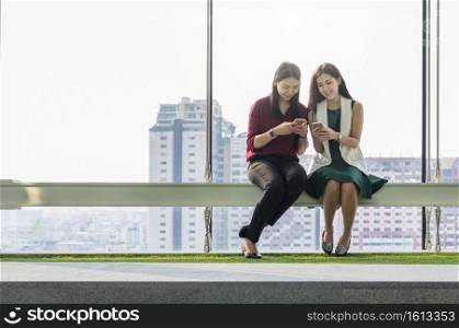 Two asian Businesswomen using the smart phone In the modern creative Office, business success concept