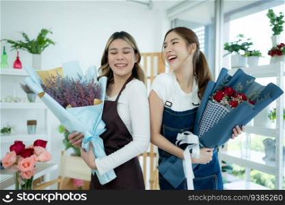 Two asian female florist holding bouquet in flower shop