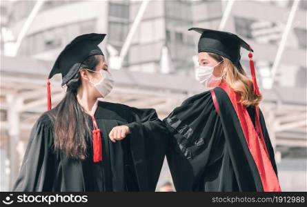 Two asian female students wearing uniform, cap, mask to protect virus after graduation. Education and health Concept.