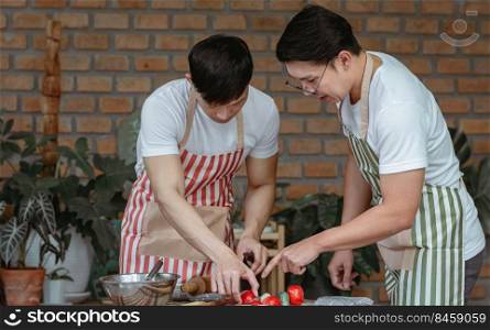 Two asian handsome men cooking together in kitchen room at home. Lifestyle, Friendship and LBGT Concept.