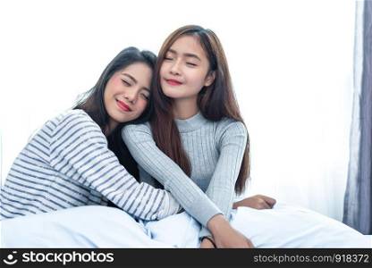 Two Asian Lesbian hug together in bedroom. Beauty concept. Happy lifestyle and home sweet home theme. Cushion pillow element and window curtain background. Love scene of lovers