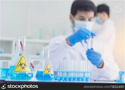 Two asian scientist team reserch chemistry science tube experiment biotech antibody sample in laboratory Cultivate Vaccine against covid-19 virus. Scientist consult, analyze in Chemistry Laboratory