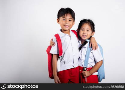 Two Asian student kid girl boy schoolchildren brother sister smile happy wear student thai uniform red pants skirt hug each other isolated on white background, Portrait little children girl preschool