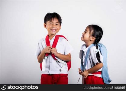 Two Asian student kid girl boy schoolchildren brother sister smile happy wear student thai uniform red pants skirt in studio shot isolated on white background, Portrait little children girl preschool