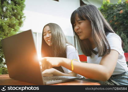 two asian teenager happiness and looking to computer labtop