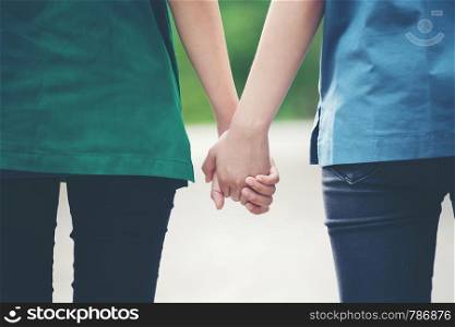 two asian woman holding hands and moving foward