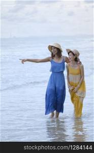 two asian woman relaxing vacation time on sea beach