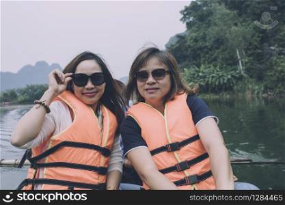 two asian woman tourist wearing lifejacket sailing boat in ninh binh canal most popular traveling destination in vietnam
