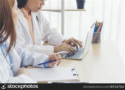 Two asian women doctors discuss meeting doctor’s office medical clinic using laptop consulting patient disease. Asian medical lab young women talking together discussing healthcare assistance teamwork