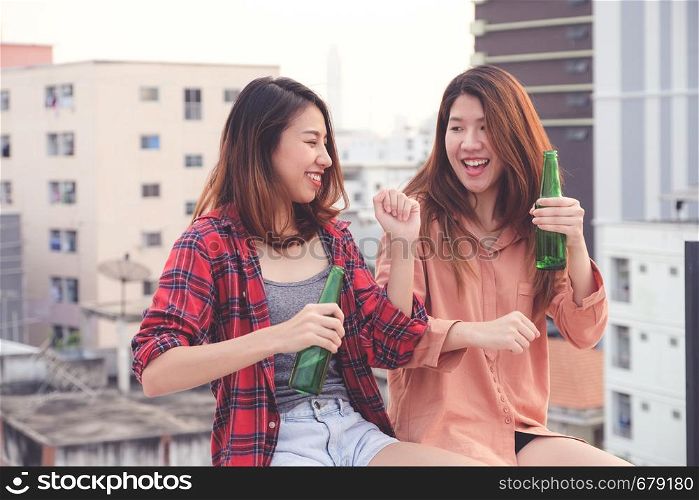 Two asian women drinking at rooftop party, outdoors celebration, friendship, LGBT couple