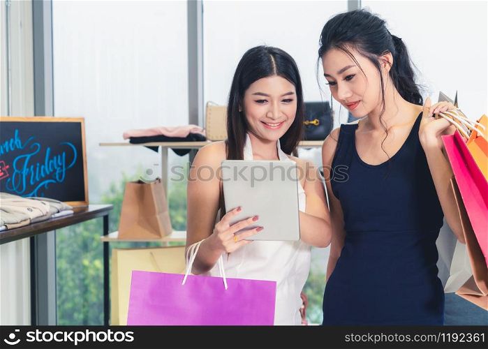 Two Asian women shopping at retail shop in the shopping mall. Modern trade lifestyle.