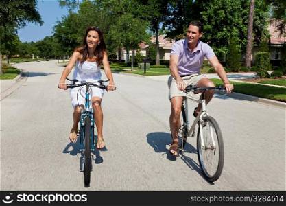 Two attractive adults, man and woman couple, cycling together, shot with a slow shutter speed and motion blur.
