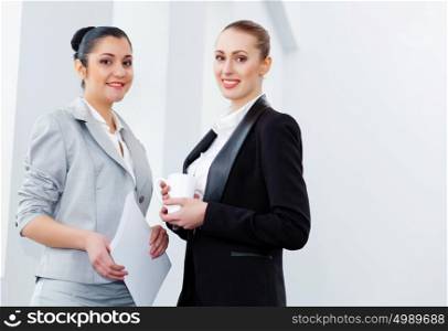 Two attractive business women smiling. Image of two young pretty businesswomen smiling