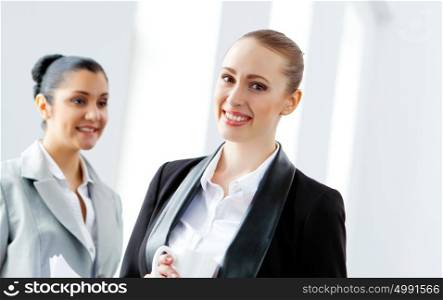 Two attractive business women smiling. Image of two young pretty businesswomen smiling