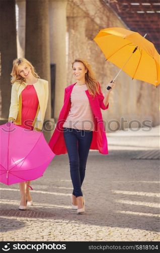 Two attractive girlfreinds with the colorful umbrellas