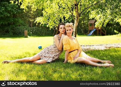 Two attractive ladies resting on the flower meadow