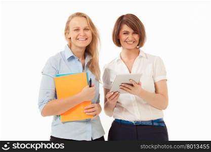 Two attractive smiling women holding folders and tablet against of white background. Isolated, studio shot.