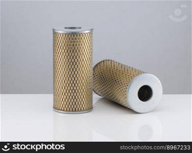 two automotive filter cylindrical shape  on a white background with reflection. automobile filter on a white background