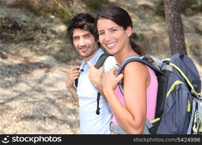 Two backpackers hiking through the forest