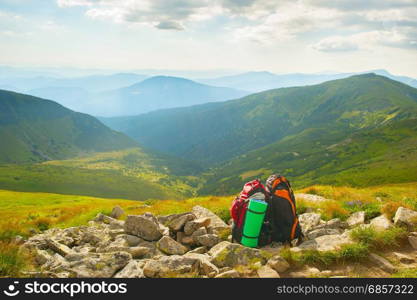 Two backpacks in the mountains at sunset