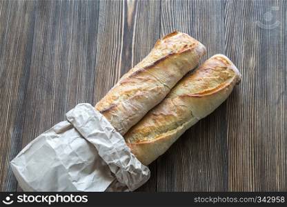 Two baguettes on the wooden background