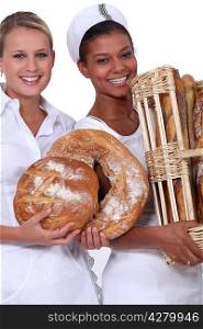Two bakery workers holding bread