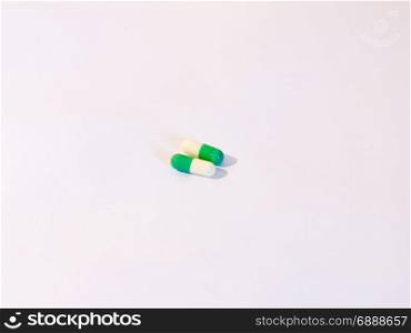 two basic generic pills on a white background white and green drugs stock photo for medical and healthcare