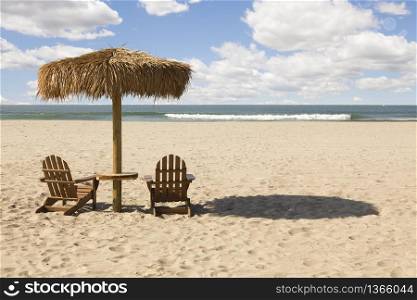 Two Beach Chairs and Umbrella on a Beautiful Ocean Front with Copy Space.