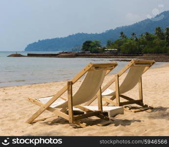 Two beach chairs on idyllic tropical sand beach.