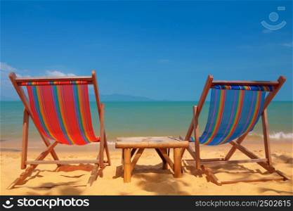 Two beach chairs on tropical shore