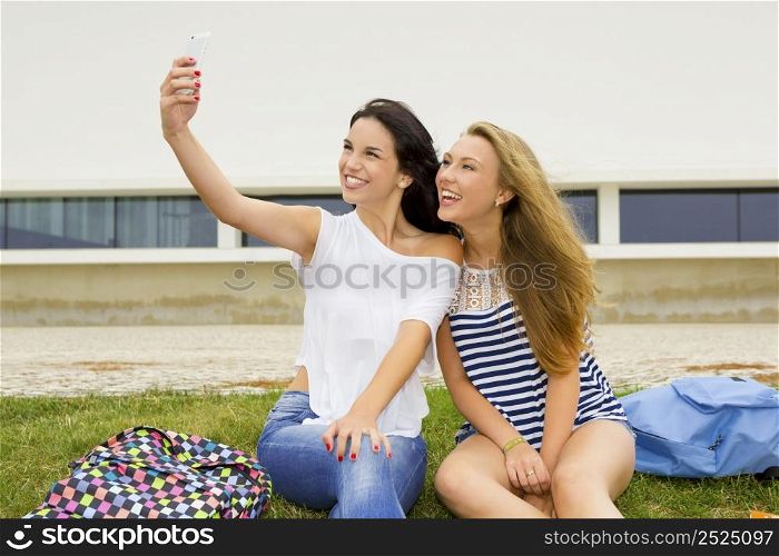 Two beautiful and happy studentsg making a selfie