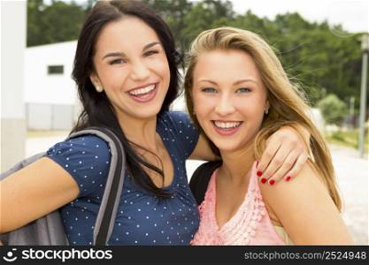Two beautiful and happy teenage students lauthing