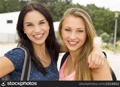 Two beautiful and happy teenage students smiling
