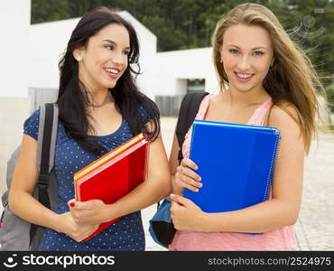 Two beautiful and happy teenage students smiling