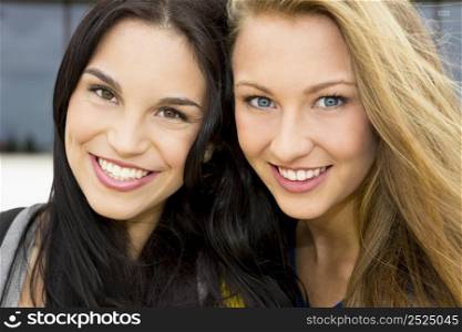 Two beautiful and happy teenage students smiling