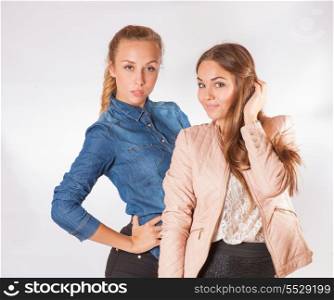 two beautiful blond woman sisters with styled blond hair on white background - not isolated.