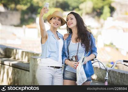 Two beautiful female friends making a selfie with cellphone