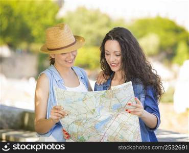 Two beautiful female friends searching a place on the map