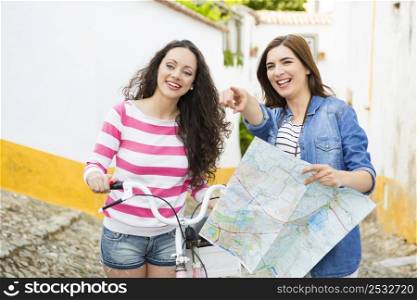 Two beautiful female tourists searching a place on the map