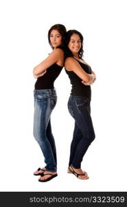 Two beautiful happy smiling young women standing together as a couple back to back, wearing blue denim jeans and blank tank tops, isolated.