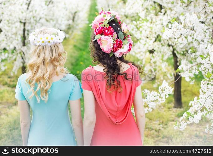 Two beautiful ladies walking along the flower alley