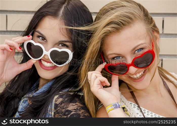 Two beautiful teenage girl wearing funny sun glasses