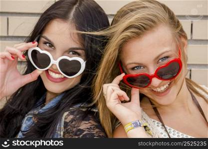 Two beautiful teenage girl wearing funny sun glasses